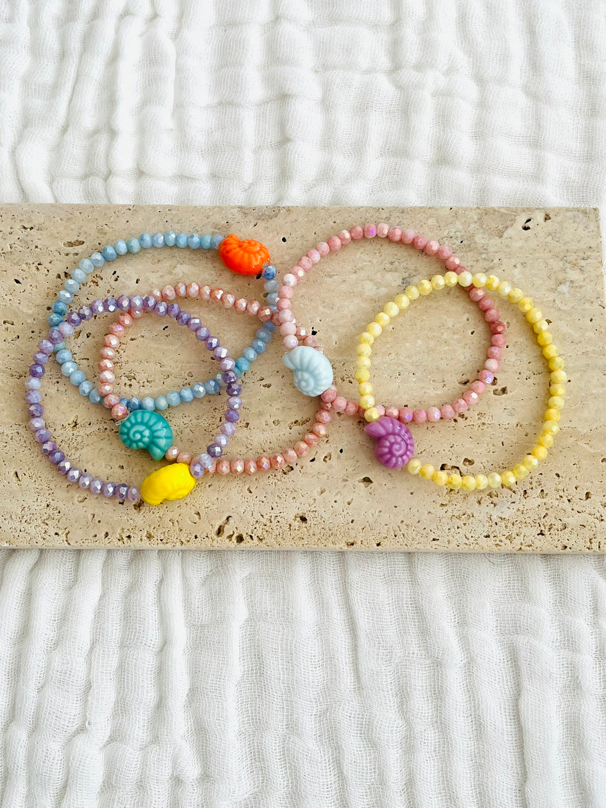 Bracelet élastique fait main.
Perles en verre facettées et perle coquillage en céramique.
Bijou fait main.