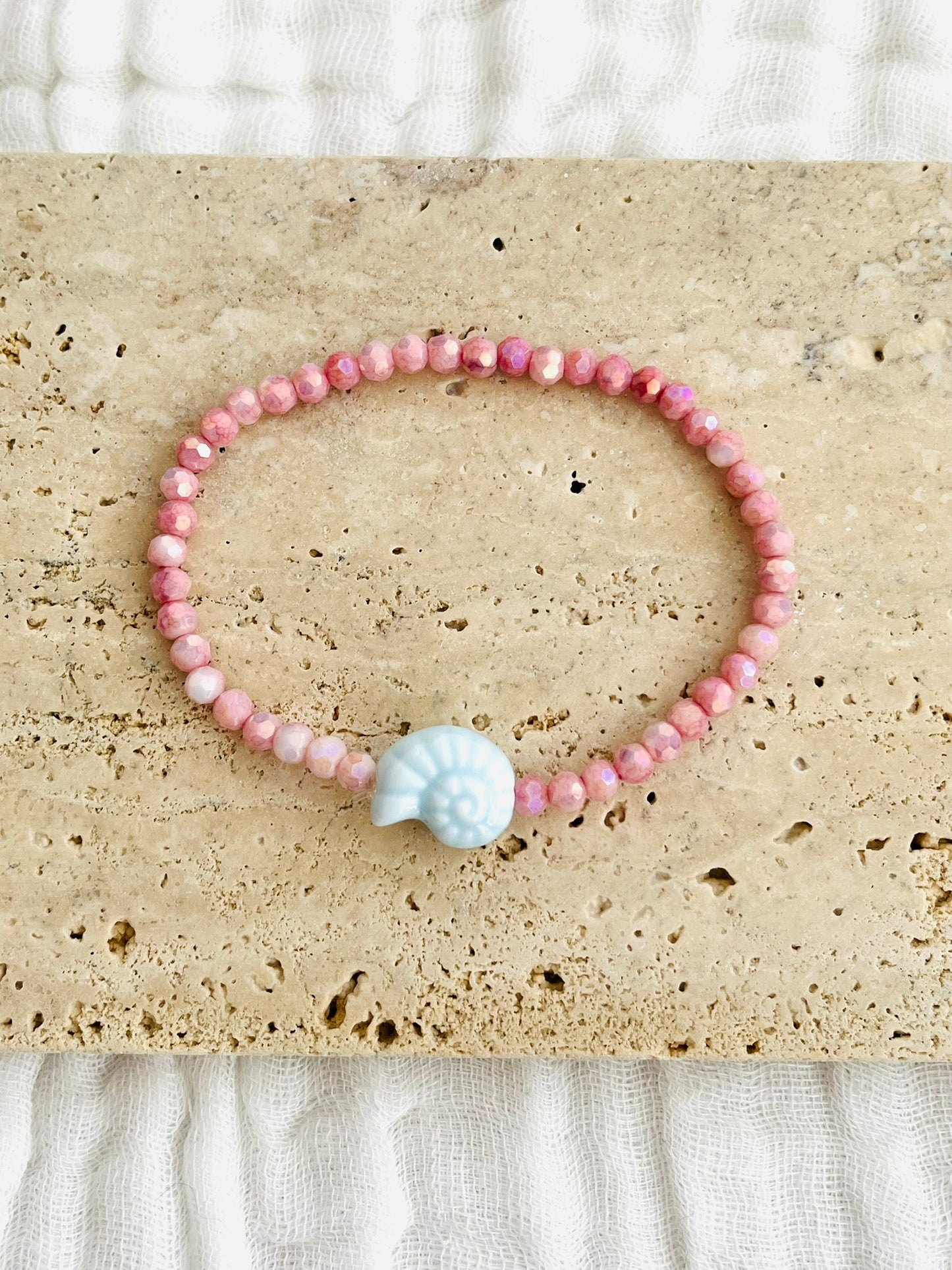 Bracelet élastique fait main.
Perles en verre facettées rose et perle coquillage en céramique bleu ciel.
Bijou fait main.