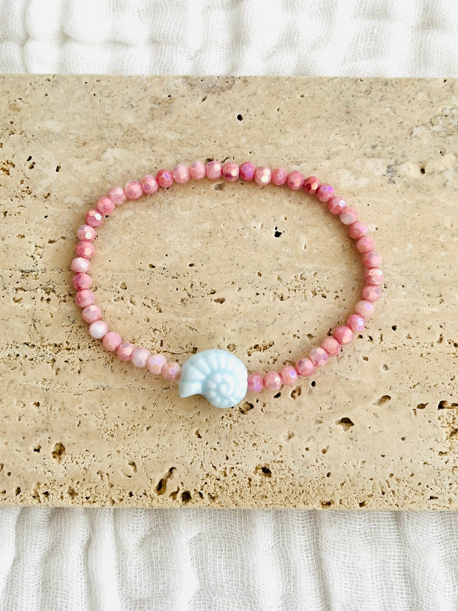 Bracelet élastique fait main.
Perles en verre facettées rose et perle coquillage en céramique bleu ciel.
Bijou fait main.