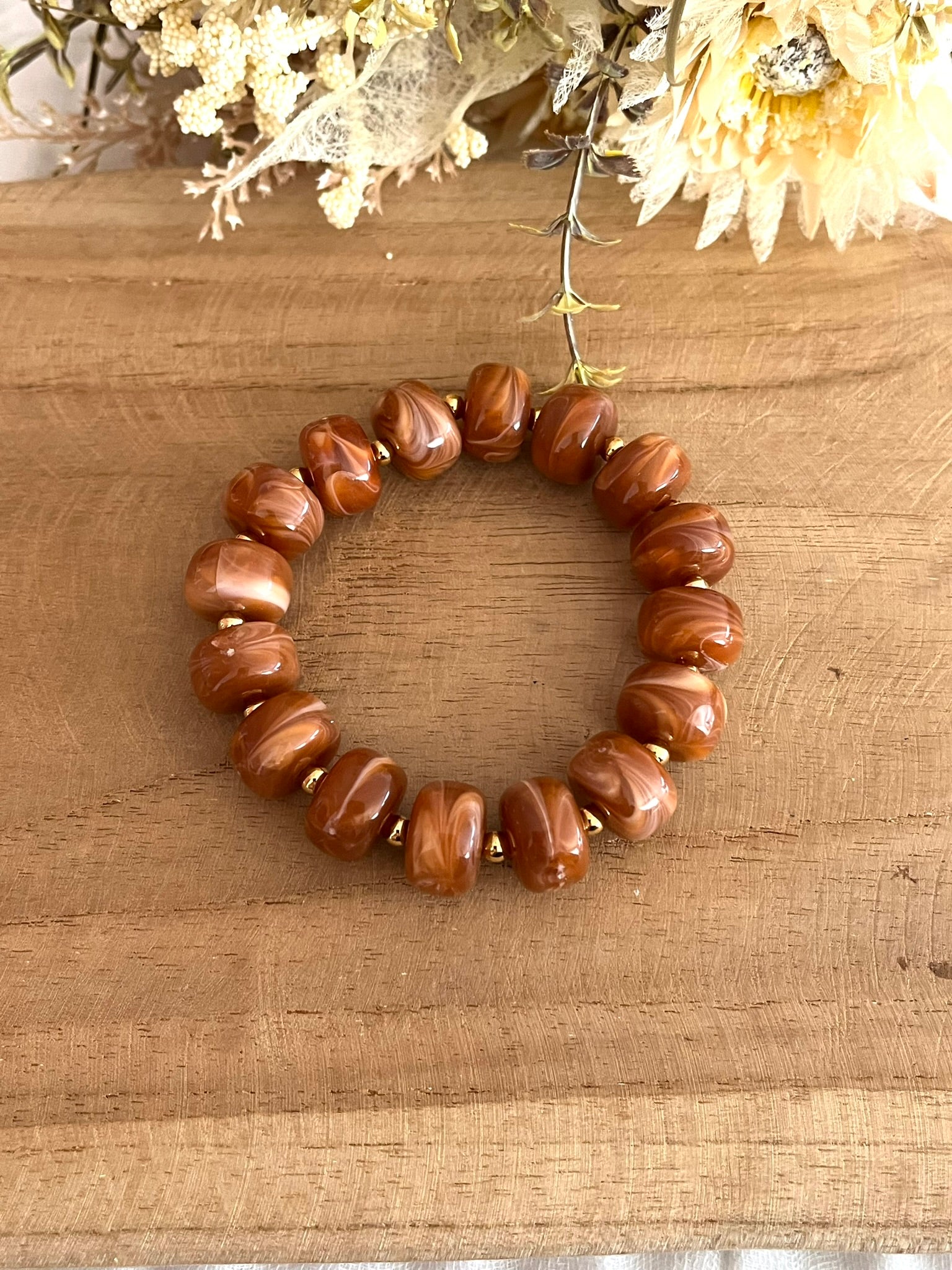 Bracelet élastique en perles résine couleur marron marbré.
Perles intercalaires en acier inoxydable doré de 4mm.
Bijou fantaisie fait main.