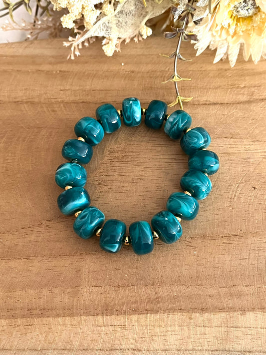 Bracelet élastique en perles résine couleur vert canard marbré.
Perles intercalaires en acier inoxydable doré de 4mm.
Bijou fantaisie fait main.