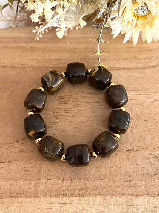 Bracelet élastique fait main.
Perles cube en résine marron chocolat, perles intercalaires rondes en acier inoxydable doré.
Bijou fantaisie fait main.