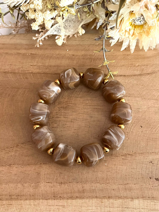 Bracelet élastique fait main.
Perles cube en résine marron moka, perles intercalaires rondes en acier inoxydable doré.
Bijou fantaisie fait main.