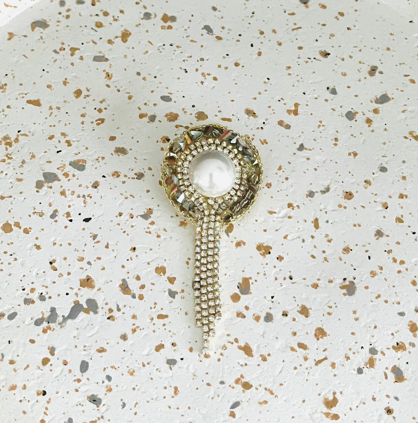 Broche fantaisie ronde grise et blanc nacré, franges de strass