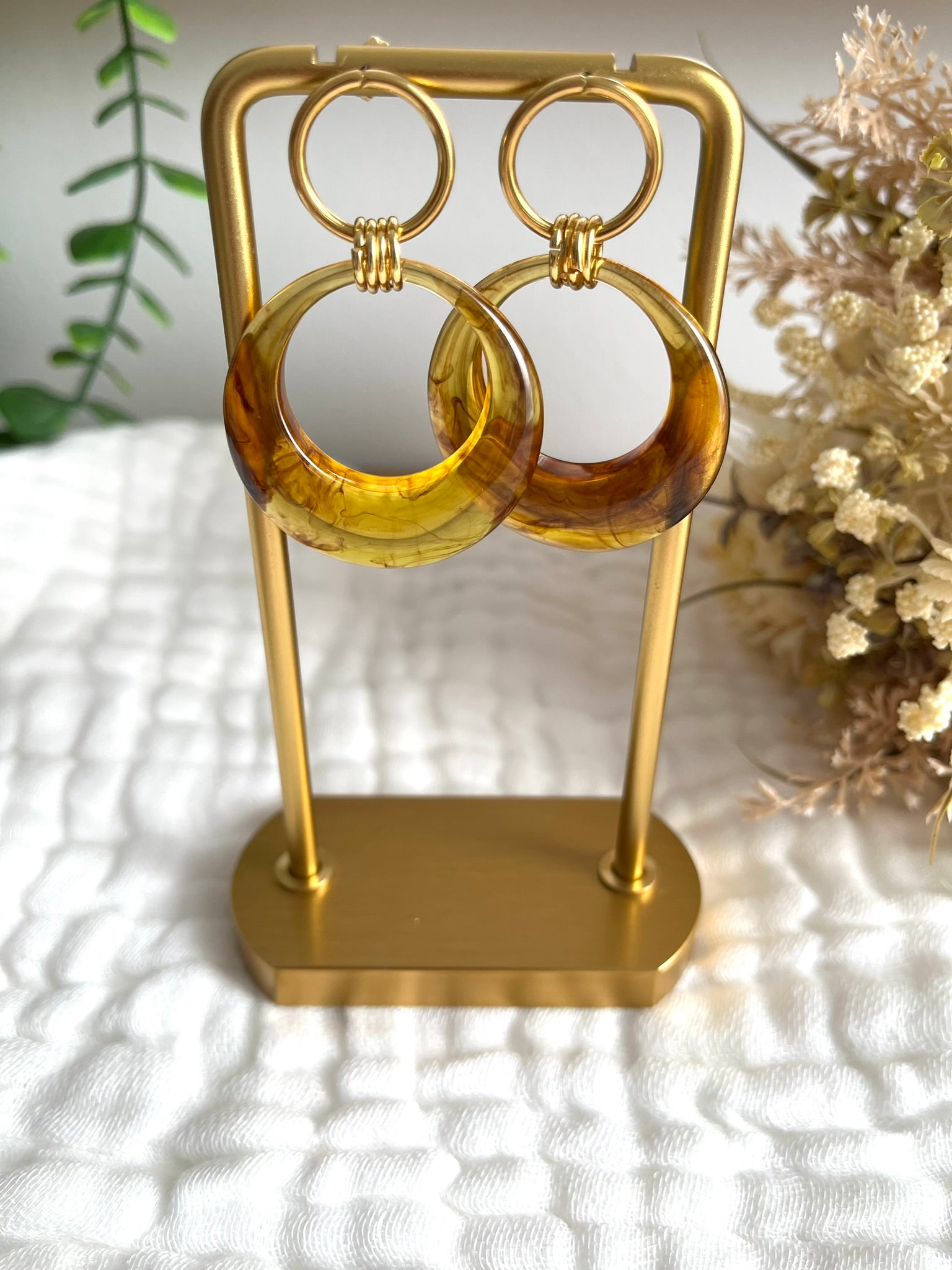 Boucles d'oreilles fantaisie fait main.
Clous d'oreilles cercle en acier inoxydable doré avec pendentif cercle en résine translucide marron ambré.
Bijou fantaisie fait main.