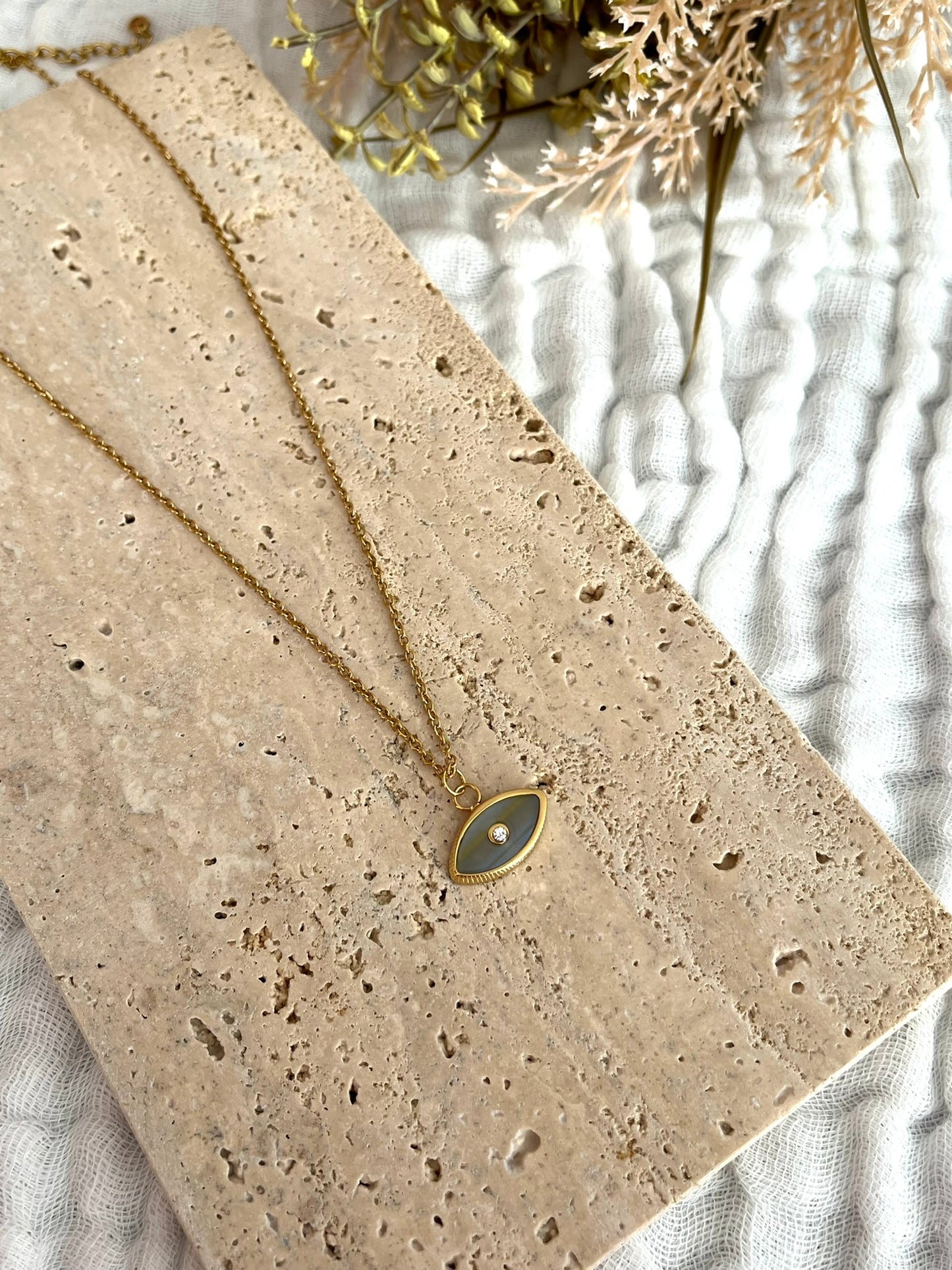 Collier fantaisie fait main.
Collier en acier inoxydable doré. Pendentif oeil gris nacré.
Bijou fantaisie fait main.