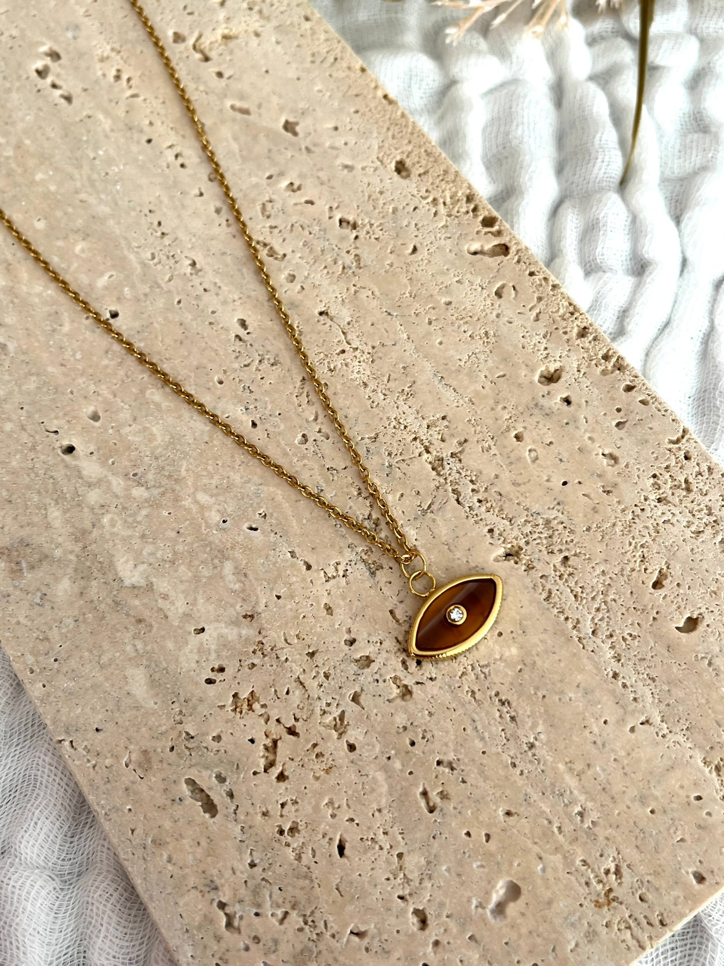 Collier fantaisie fait main.
Collier en acier inoxydable doré. Pendentif oeil marron - ambre.
Bijou fantaisie fait main.