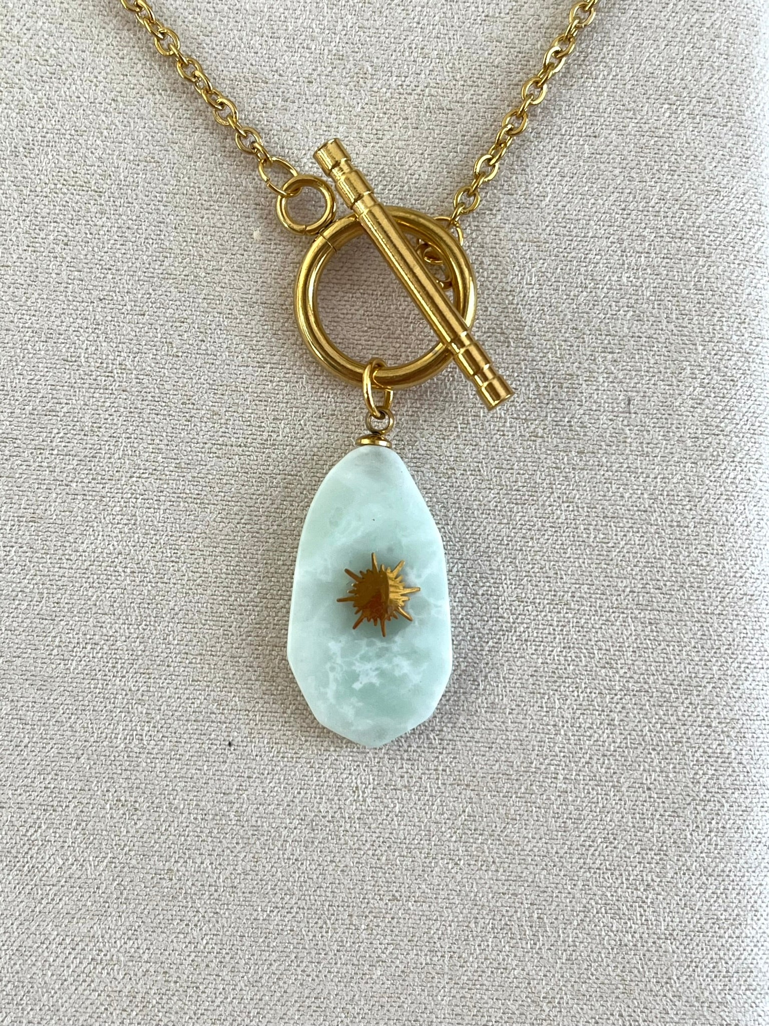 Collier fantaisie fait main en acier inoxydable doré.
Pendentif en pierre couleur vert d'eau.
Bijou fantaisie fait main.