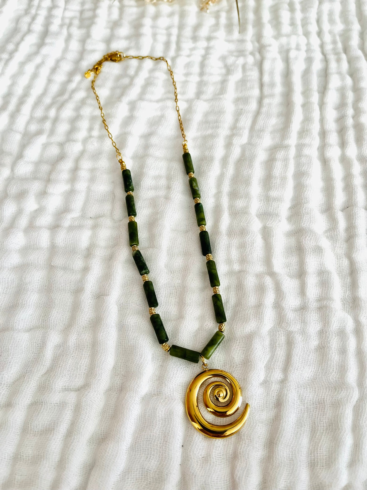 Collier fantaisie fait main.
Chaîne en acier doré et perles tubes en pierre naturelle marbre vert olive.
Pendentif spirale en acier inox doré.
Bijou fait main.