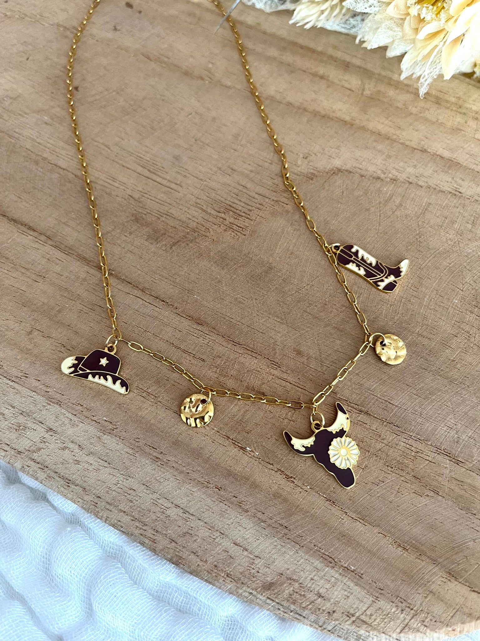 Collier fantaisie fait main.
Collier à breloques en acier inoxydable doré. Thème western, cow-boy. Charms en acier émaillé marron et beige: santiag, tête de buffle, chapeau de cow-boy.
Bijou fantaisie fait main.