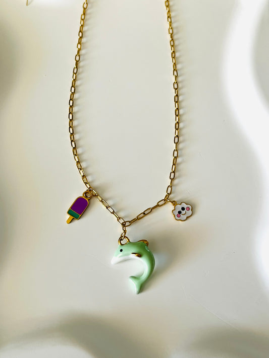 Collier adapté pour les enfants à partir de 6 ans.
Collier en acier inoxydable doré, hypoallergénique.
Breloques dauphin vert d'eau, nuage blanc et glace violet.