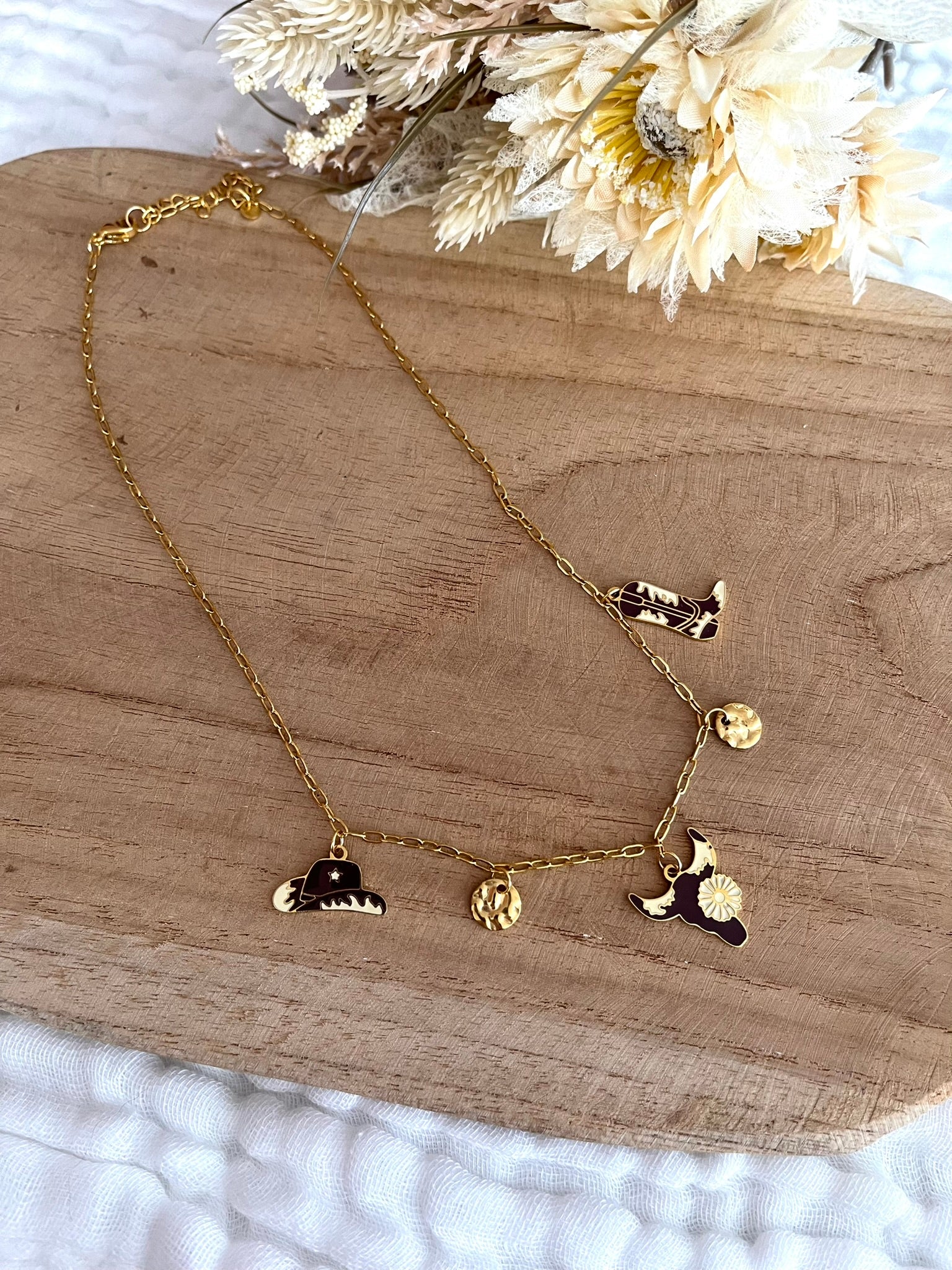 Collier fantaisie fait main.
Collier à breloques en acier inoxydable doré. Thème western, cow-boy. Charms en acier émaillé marron et beige: santiag, tête de buffle, chapeau de cow-boy.
Bijou fantaisie fait main.