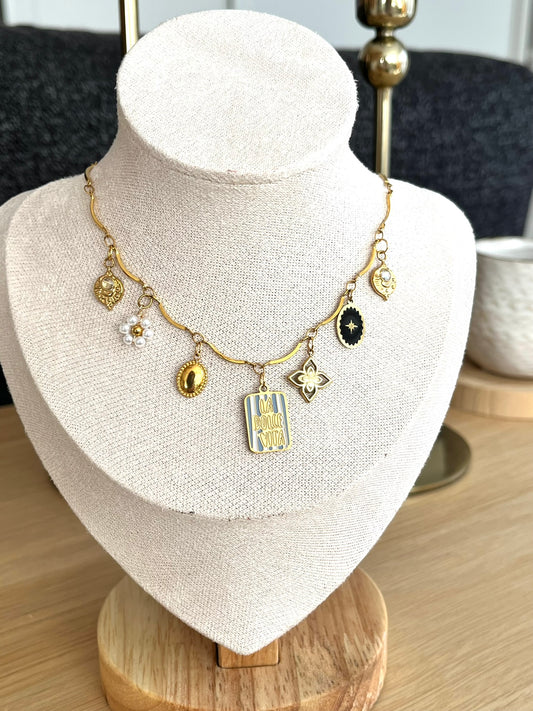 Collier fantaisie fait main.
Collier en acier inoxydable avec pampilles: Fleur, étoile, limule en acier doré.
Pendentif central rectangle rayé gris et blanc gravé "Dolce Vita"