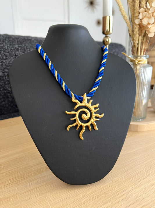 Collier corde tressée bleu et doré avec pendentif soleil en acier inoxydable doré.
Bijou fantaisie fait main.