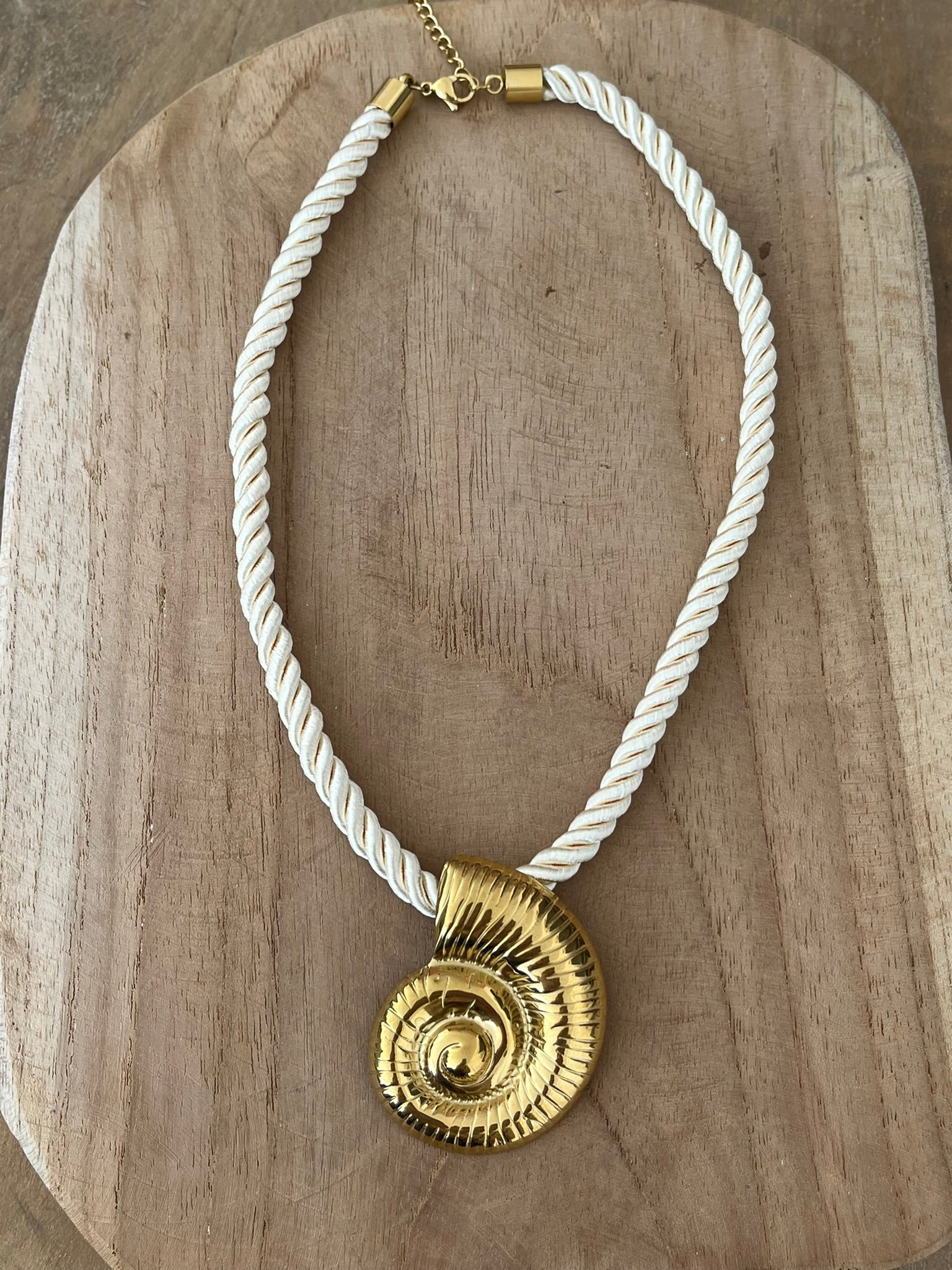 Collier corde tressée écru avec pendentif coquillage en acier inoxydable doré.
Bijou fantaisie fait main.
