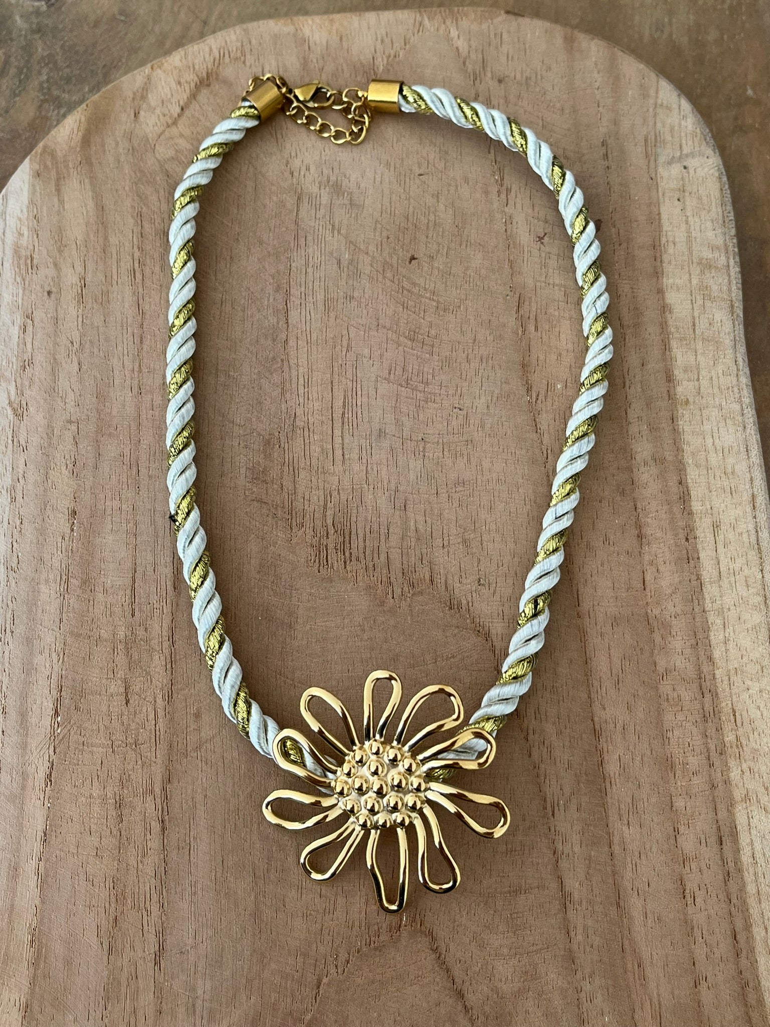 Collier corde tressée écru et doré avec pendentif fleur en acier inoxydable doré.
Bijou fantaisie fait main.