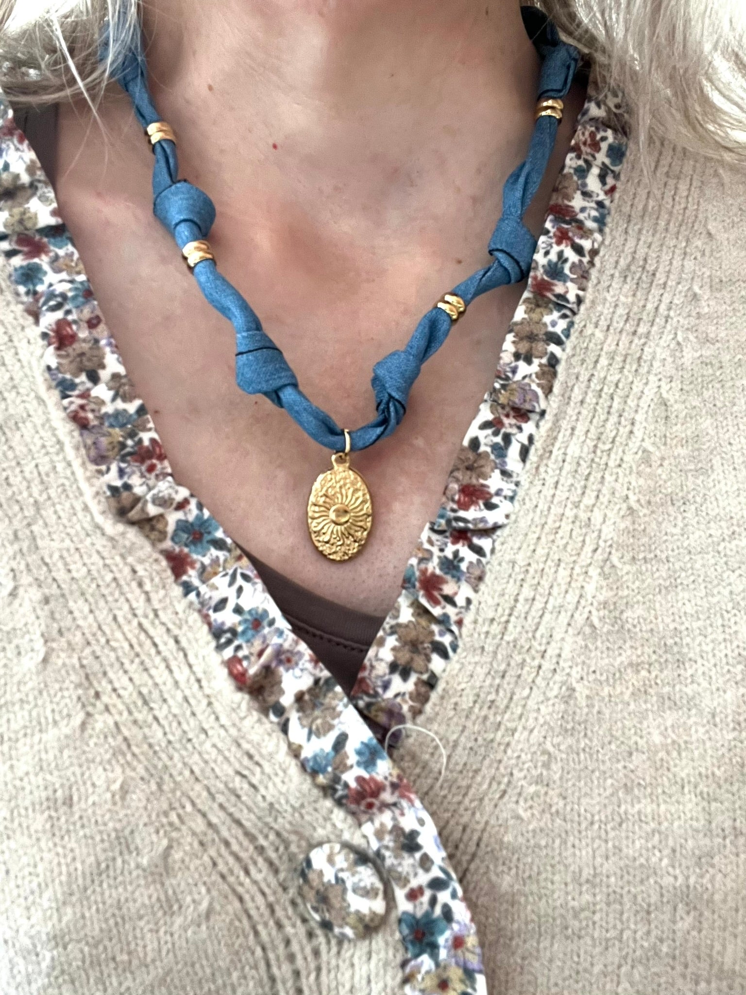 Collier en tissu bleu denim et pendentif ovale motif soleil.
Tissu en coton denim et pendentif en acier inoxydable doré.
Longueur: 44cm + 5cm
Bijou fantaisie fait main.