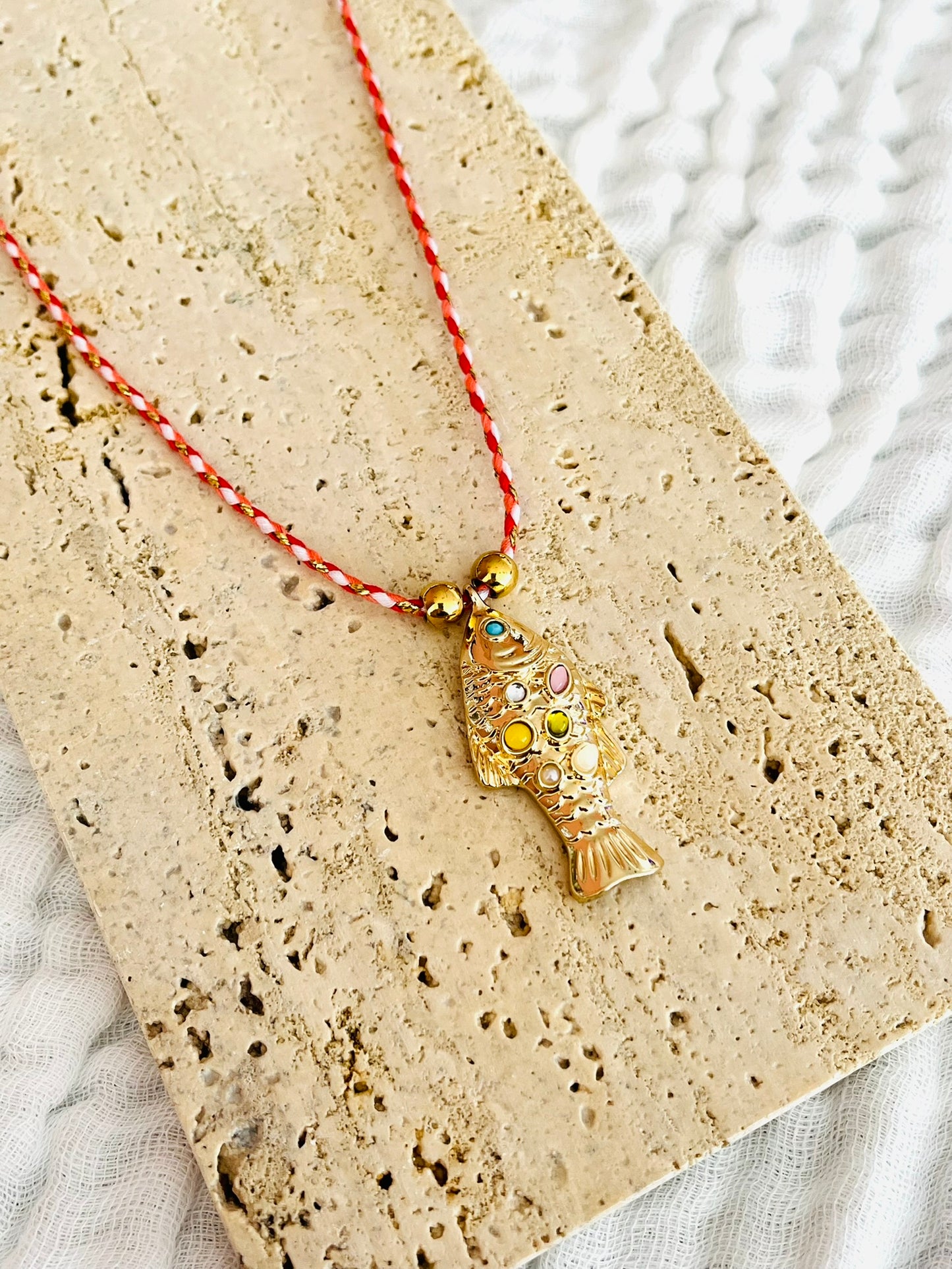 Collier fantaisie fait main.
Collier en cordon tresse en coton rose, turquoise, doré.
Pendentif poisson doré orné de pierres rose, jaune, vert.
Longueur de 41 à 46 cm.
Bijou fantaisie fait main