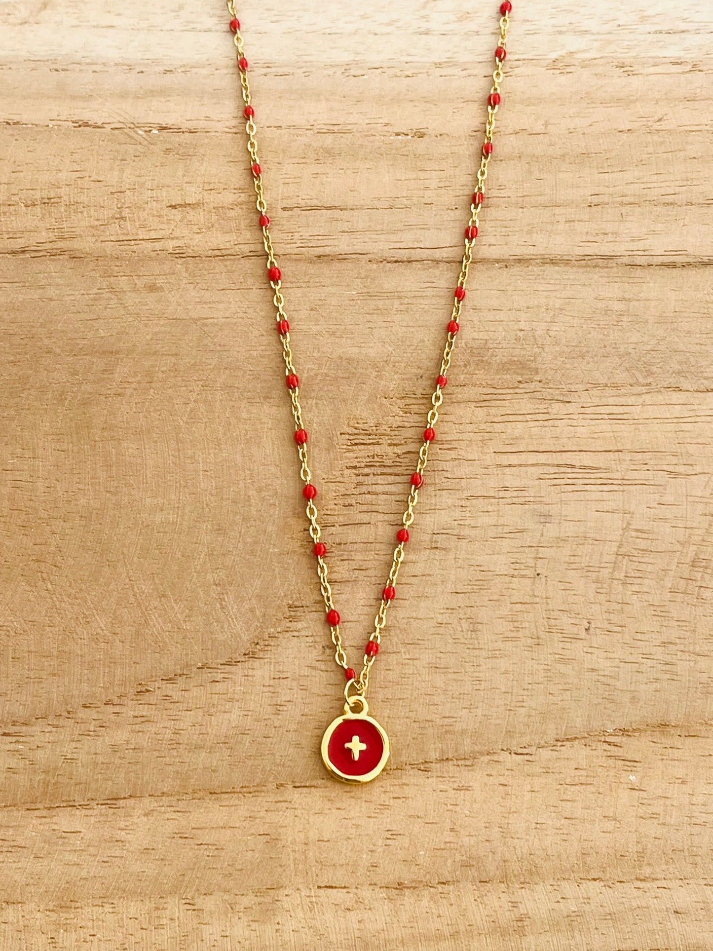Collier fantaisie en acier inoxydable doré et résine epoxy rouge.
Pendentif rond avec une croix.
Bijou fantaisie fait main.