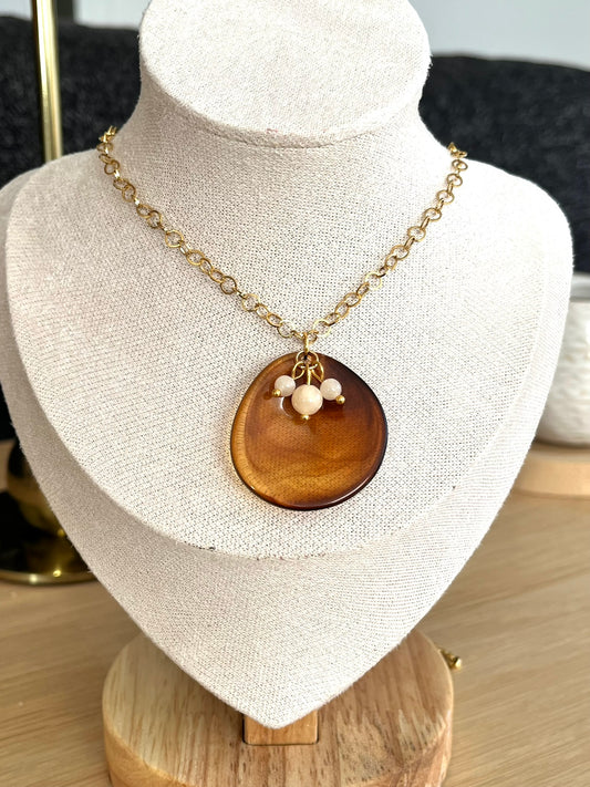 Collier fantaisie fait main.
Chaîne en acier inox doré, pendentif pétale en acrylique marron ambré, 3 perles de jade couleur nude.
Bijou fait main.
