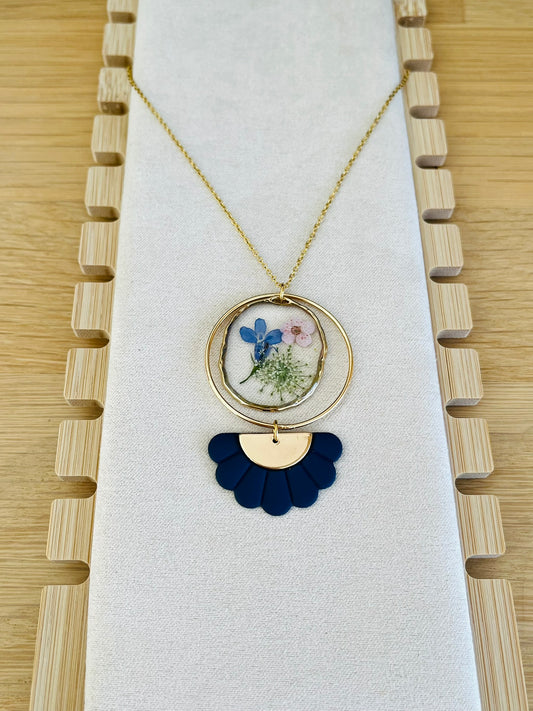 Collier fantaisie fait main.
Chaine fine en acier inoxydable doré; pendentif rond en résine avec fleurs séchées rose; pendentif demi-fleur bleu marine.
Bijou fantaisie fait main.