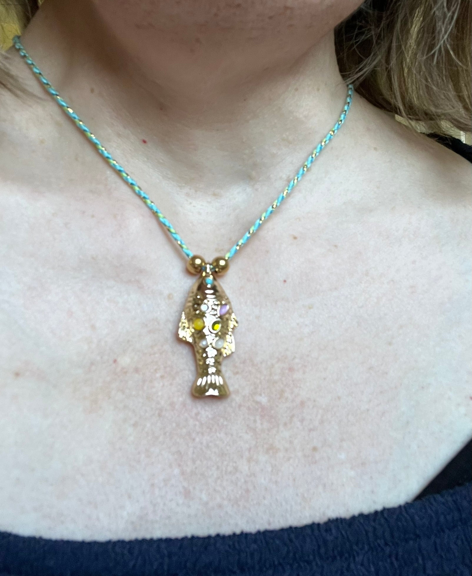 Collier fantaisie fait main.
Collier en cordon tresse en coton vert, turquoise, doré.
Pendentif poisson doré orné de pierres rose, jaune, vert.
Longueur de 41 à 46 cm.
Bijou fantaisie fait main.