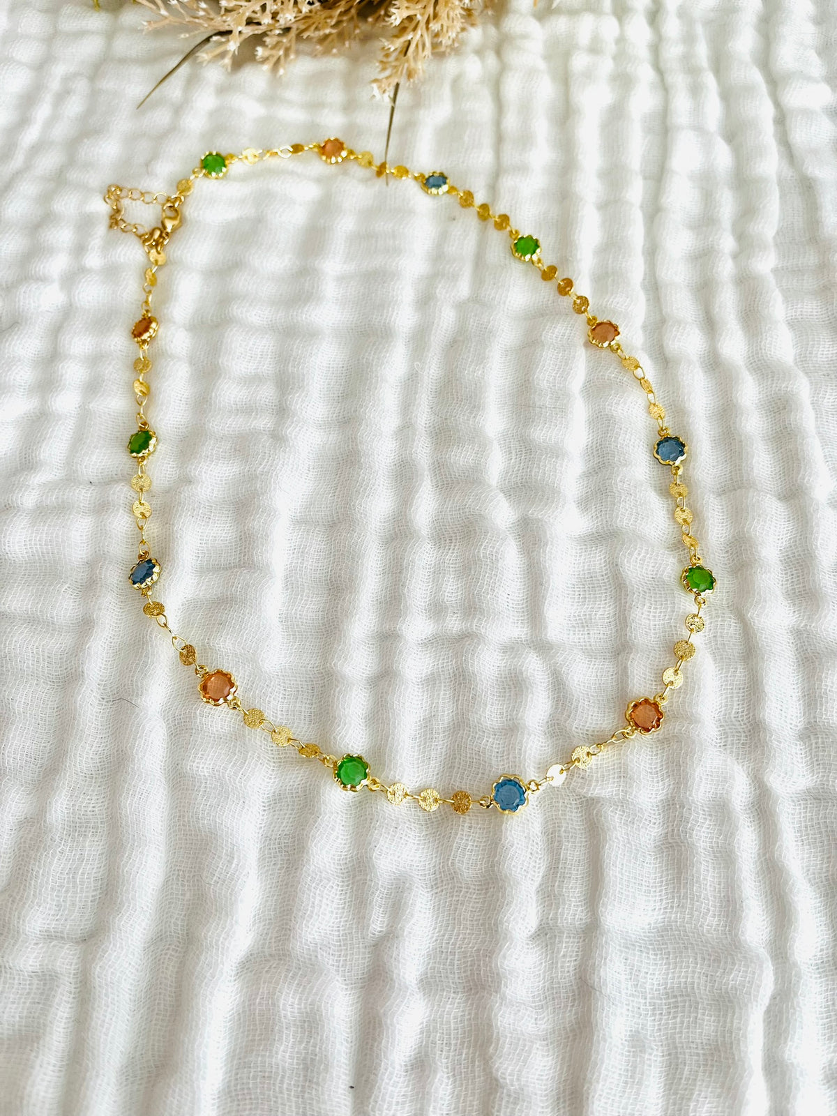Collier fantaisie fait main.
Chaîne en laiton doré sertie de cristaux en verre rose, bleu, vert.