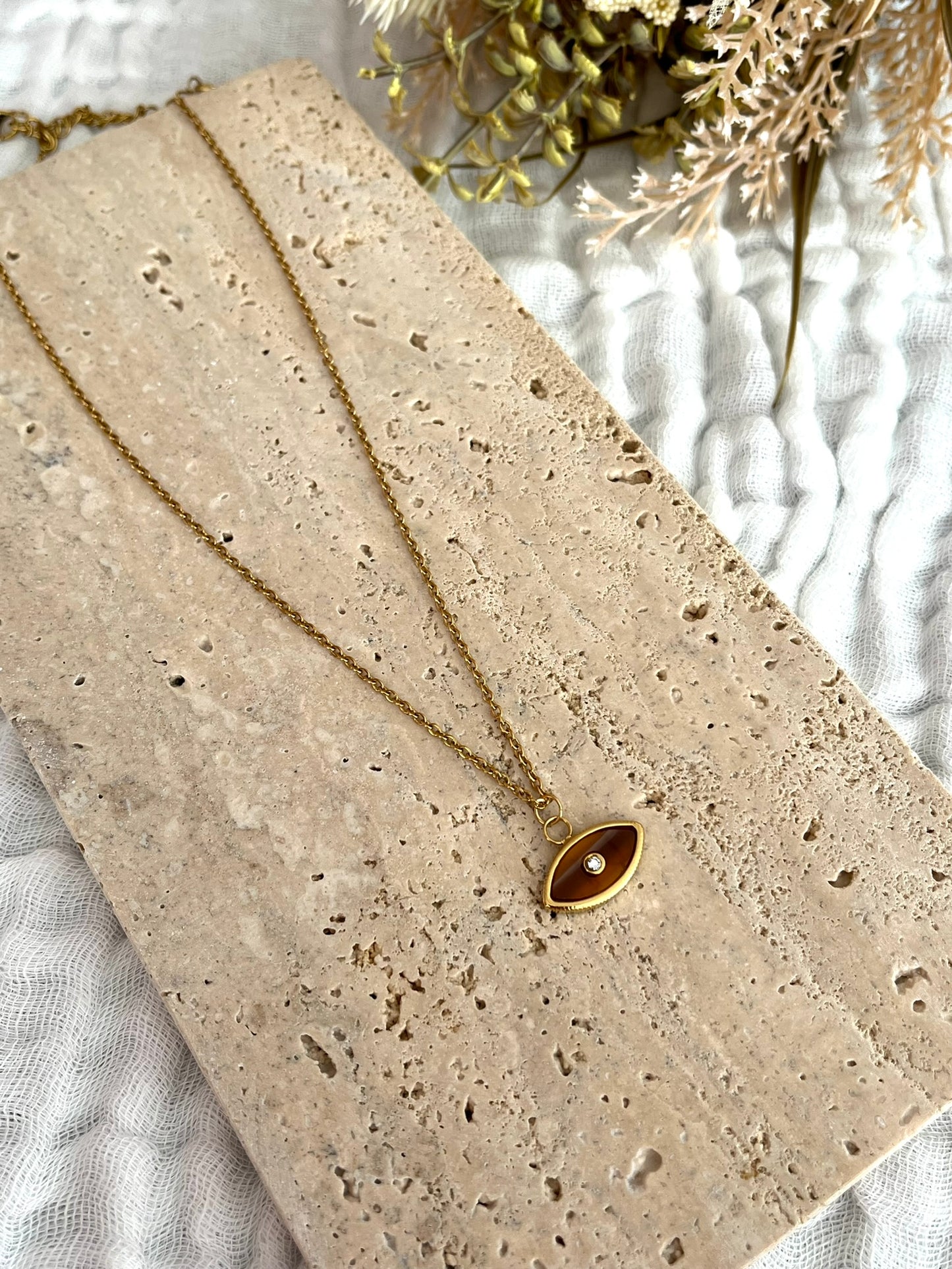 Collier fantaisie fait main.
Collier en acier inoxydable doré. Pendentif oeil marron - ambre.
Bijou fantaisie fait main.