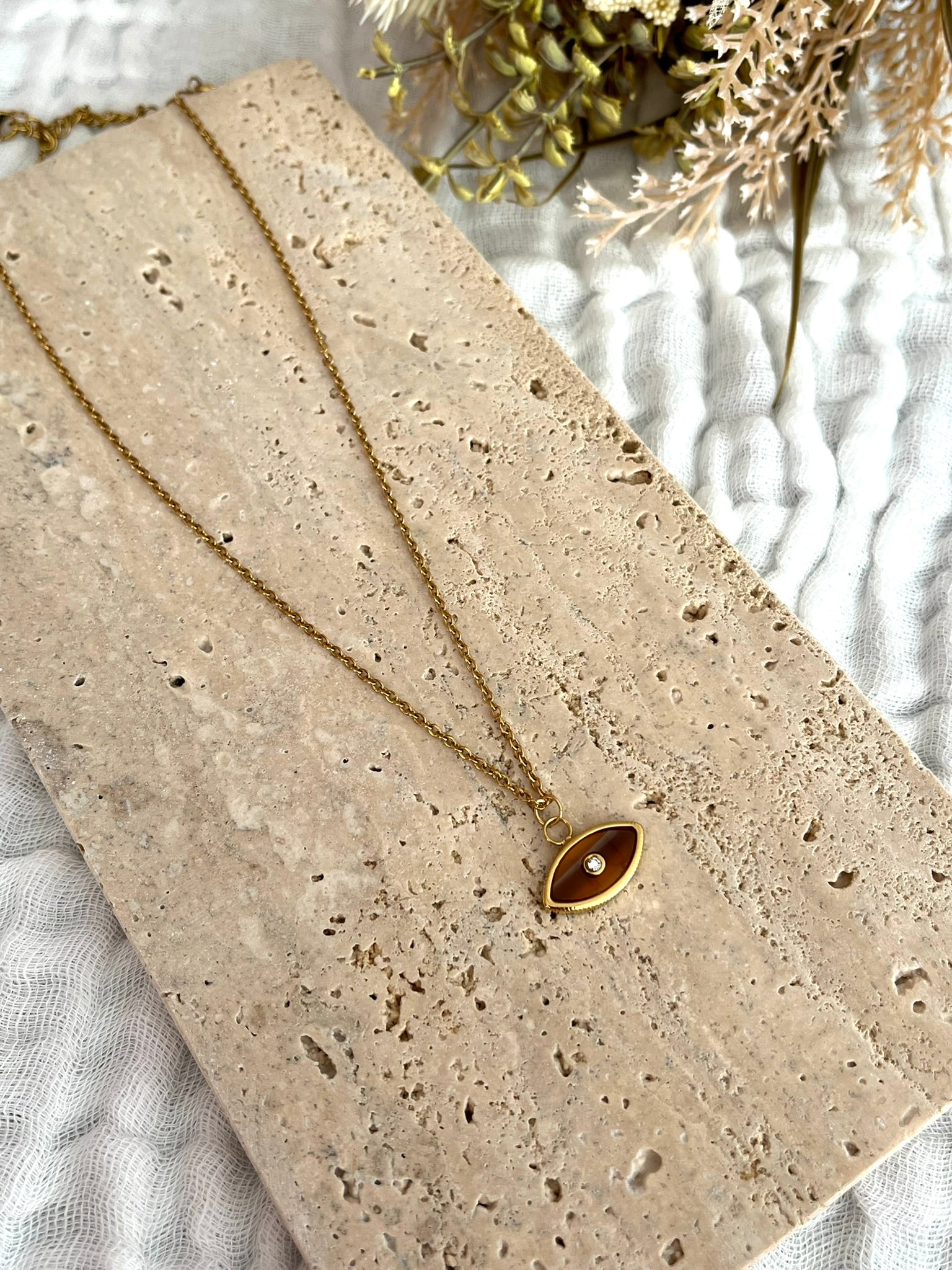 Collier fantaisie fait main.
Collier en acier inoxydable doré. Pendentif oeil marron - ambre.
Bijou fantaisie fait main.