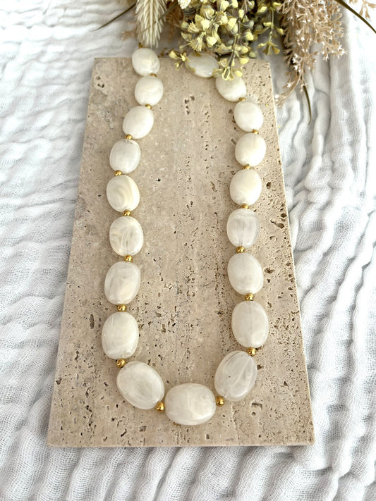 Collier fantaisie fait main.
Perles ovales en résine blanc cassé marbré.
Petites perles intercalaires ronde en acier doré.
Bijou fantaisie fait main.