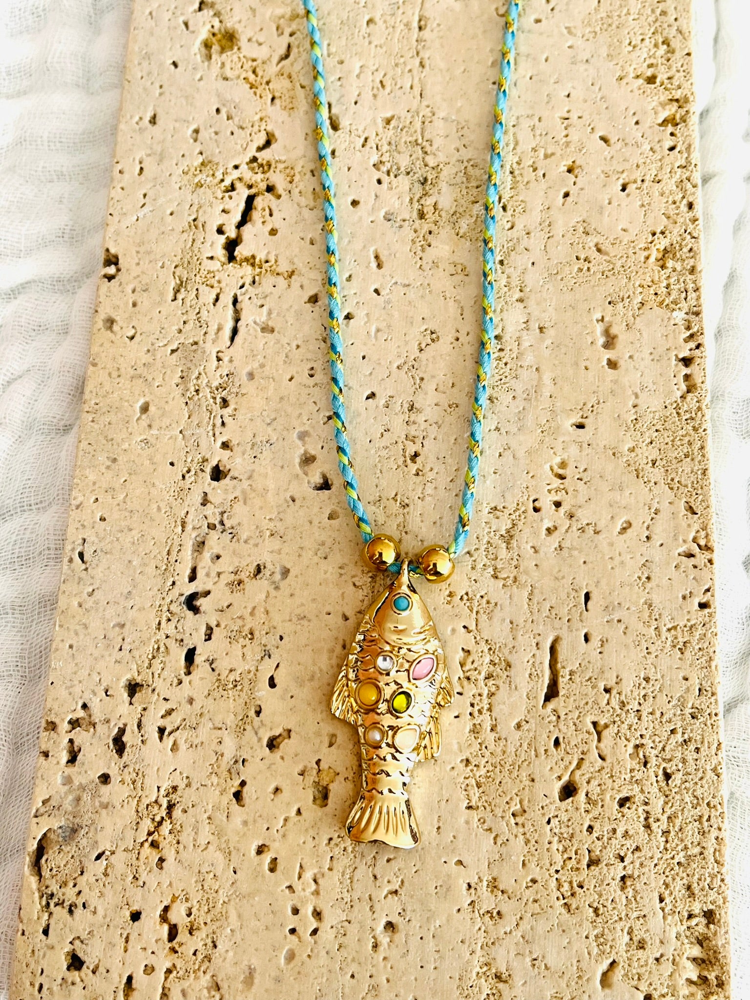 Collier fantaisie fait main.
Collier en cordon tresse en coton vert, turquoise, doré.
Pendentif poisson doré orné de pierres rose, jaune, vert.
Longueur de 41 à 46 cm.
Bijou fantaisie fait main.
