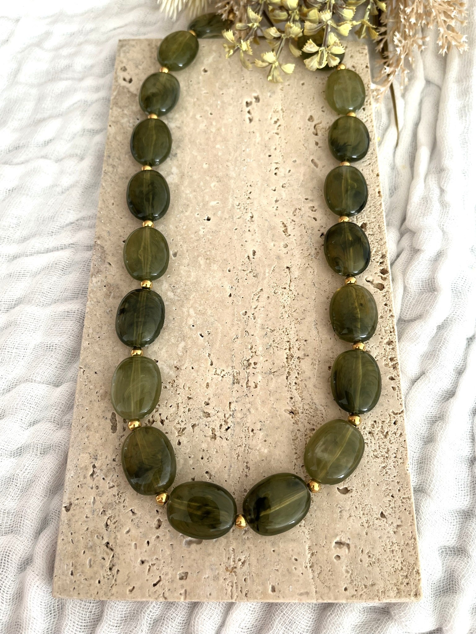Collier fantaisie fait main.
Perles ovales en résine vert olive.
Petites perles intercalaires ronde en acier doré.
Bijou fantaisie fait main.
