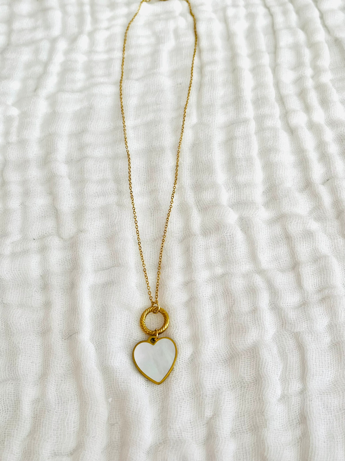 Collier fantaisie femme fait main.
Chaîne en acier inoxydable doré, anneau ciselé de 12mm en acier inox. Pendentif coeur en nacre.
Collier ajustable de 40 à 45 cm
Bijou fait main.
