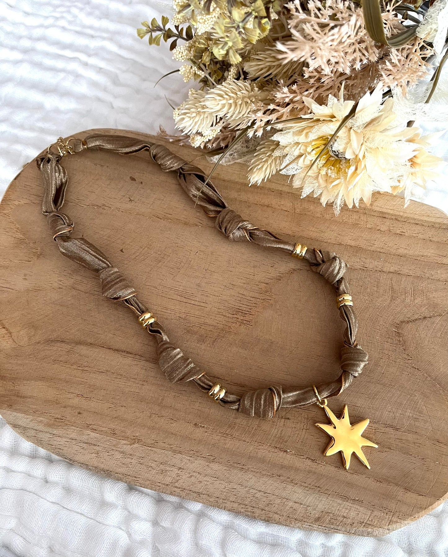 Collier en tissu couleur taupe et pendentif étoile doré
Tissu satiné et pendentif en acier inoxydable.
Longueur: 44cm + 5cm
Bijou fantaisie fait main.