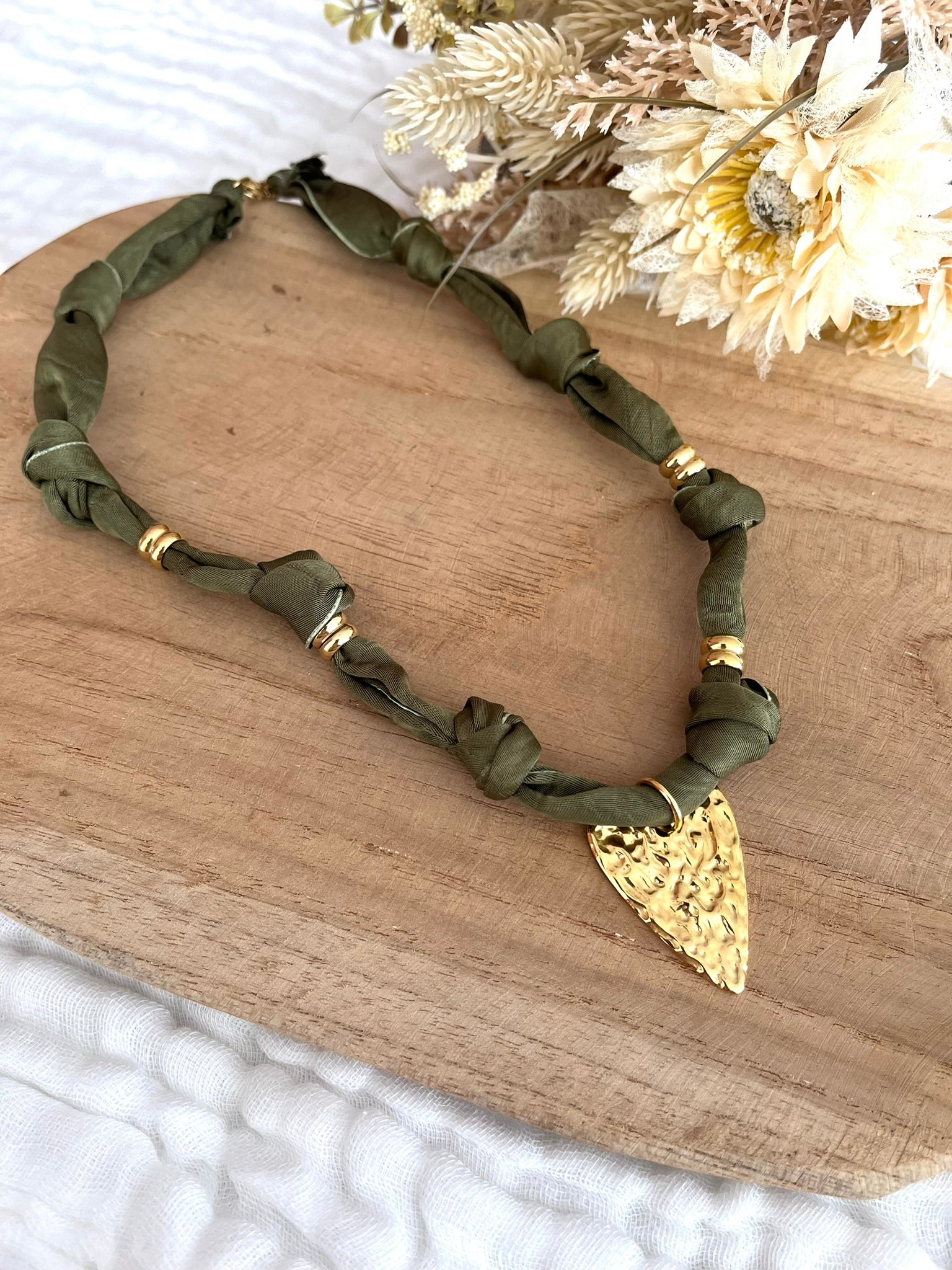 Collier en tissu vert kaki et pendentif coeur martelé
Tissu satiné et pendentif en acier inoxydable doré.
Longueur: 44cm + 5cm
Bijou fantaisie fait main.