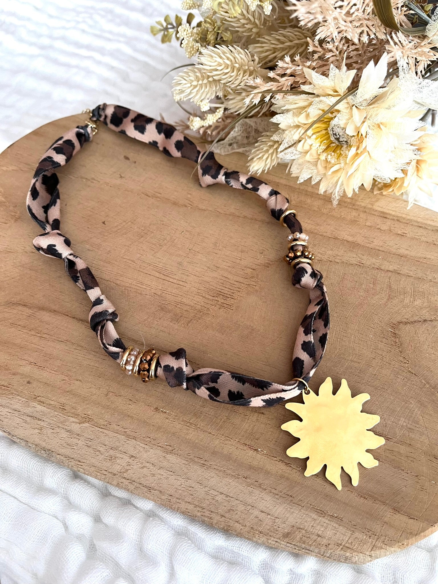 Collier en tissu mprimé léopard et pendentif soleil.
Tissu satiné et pendentif en acier inoxydable.
Longueur: 44cm + 5cm
Bijou fantaisie fait main.