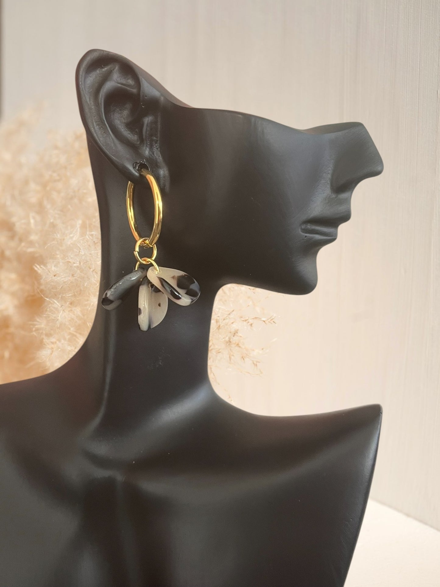 Boucles d'oreilles créoles en acier inoxydable doré. Pétales en acrylique beige et noir. Bijou fantiaisie fait main.