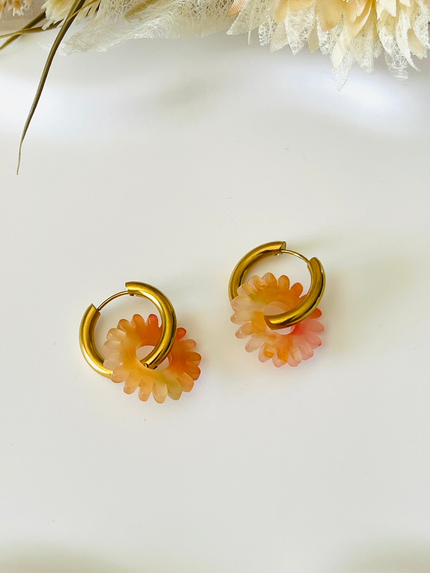 Boucles d'oreilles fantaisie.
Créoles en acier inoxydable doré.
Pampilles fleur, marguerite en acrylique orange.
Bijou fantaisie fait main.