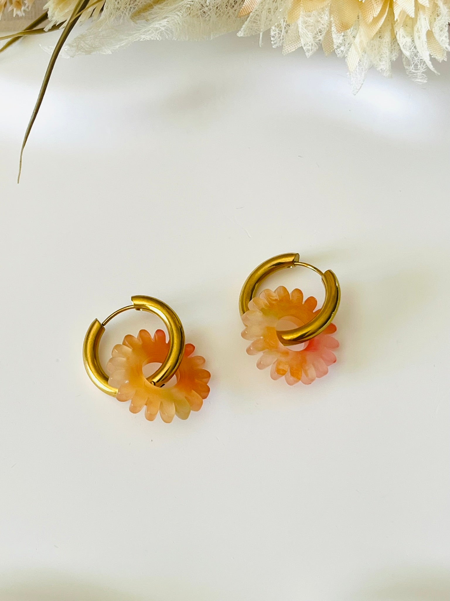 Boucles d'oreilles fantaisie.
Créoles en acier inoxydable doré.
Pampilles fleur, marguerite en acrylique orange.
Bijou fantaisie fait main.
