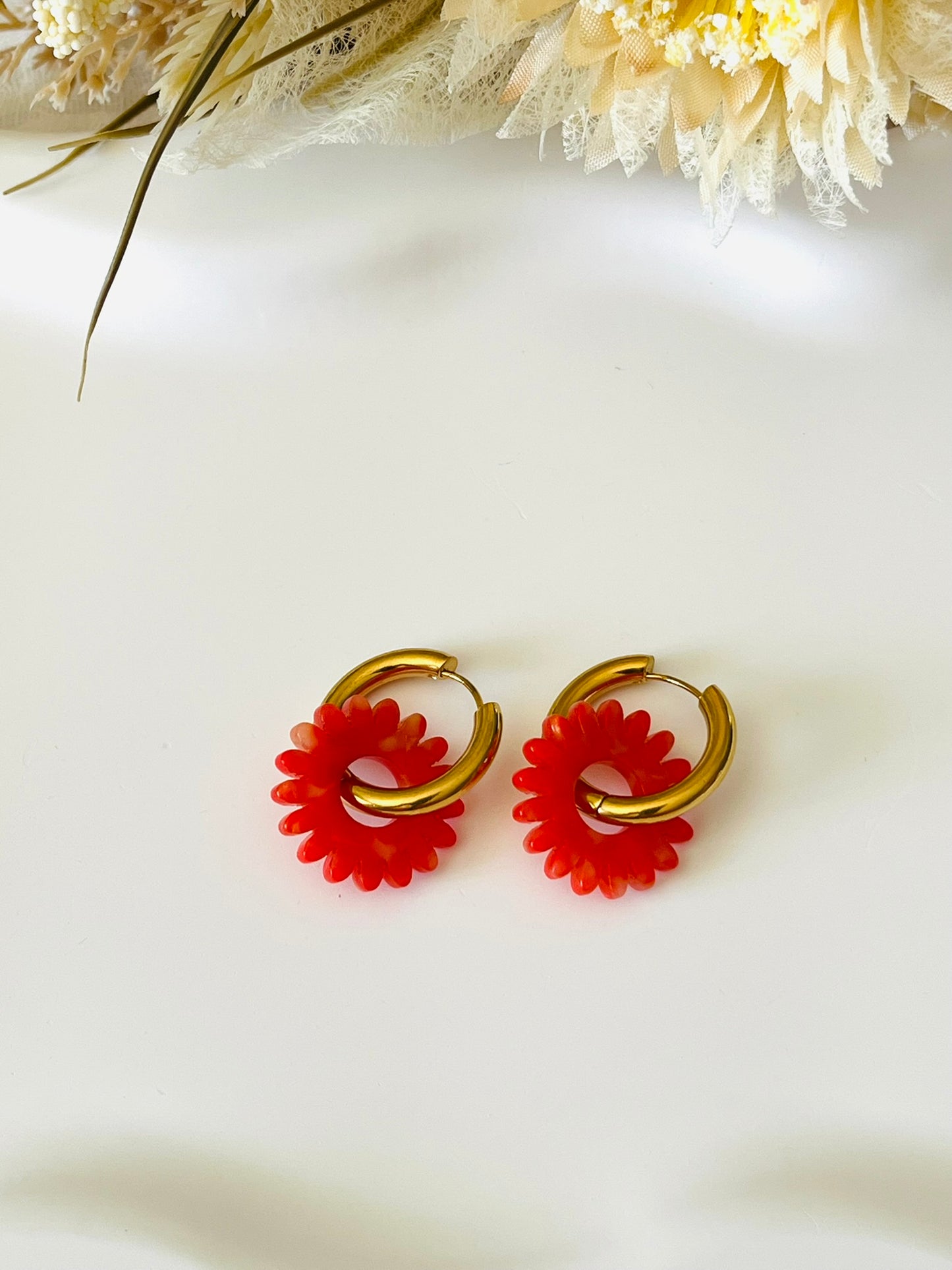 Boucles d'oreilles fantaisie.
Créoles en acier inoxydable doré.
Pampilles fleur, marguerite en acrylique rouge-orange.
Bijou fantaisie fait main.
