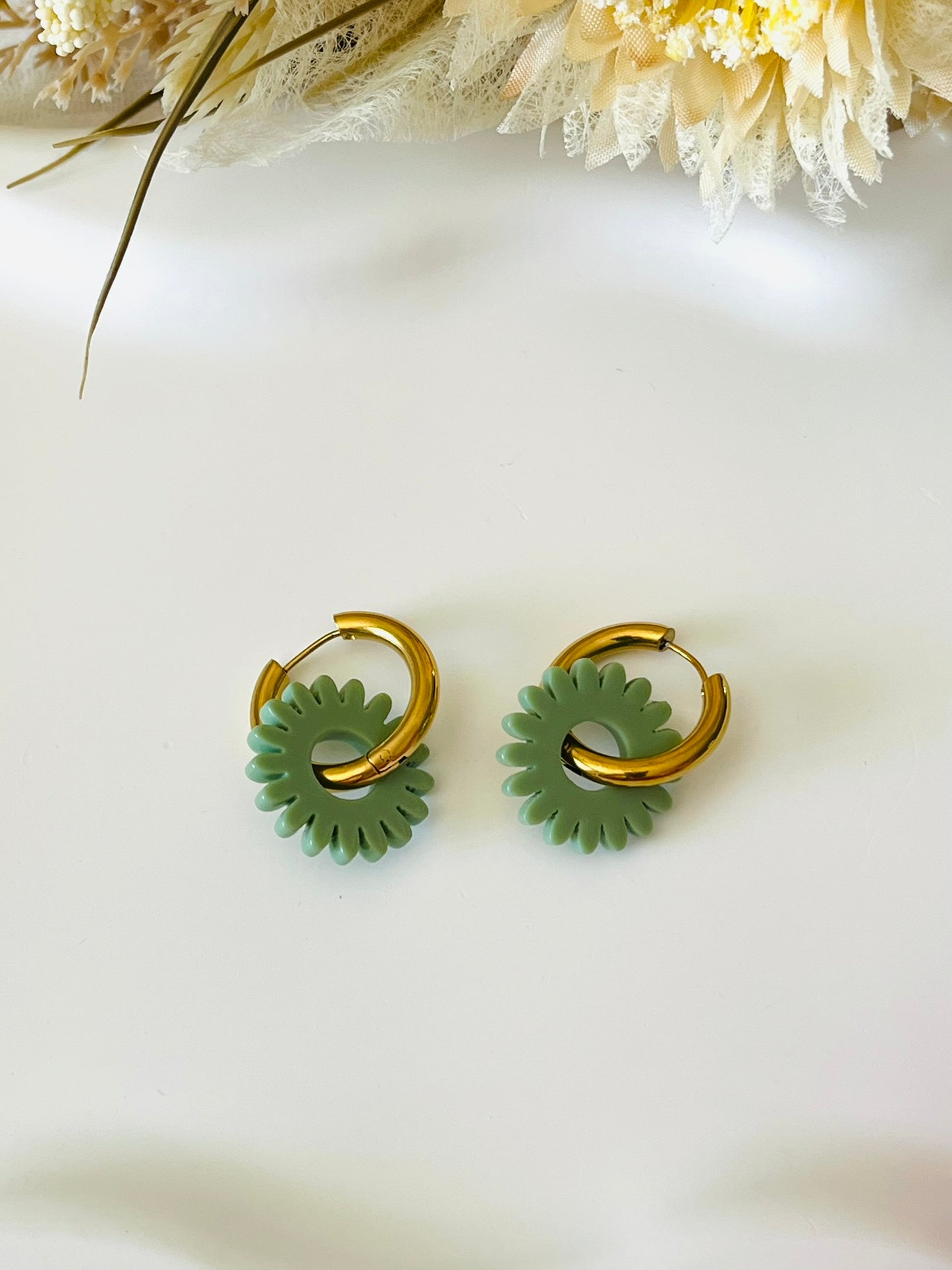 Boucles d'oreilles fantaisie.
Créoles en acier inoxydable doré.
Pampilles fleur, marguerite en acrylique vert sauge.
Bijou fantaisie fait main.