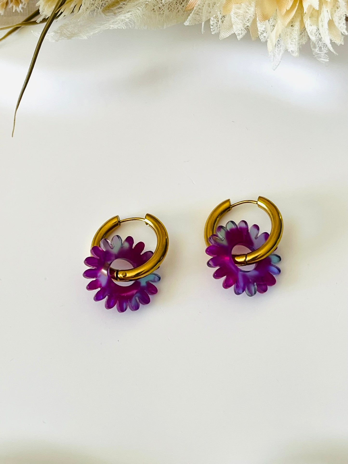 Boucles d'oreilles fantaisie.
Créoles en acier inoxydable doré.
Pampilles fleur, marguerite en acrylique violet-vert.
Bijou fantaisie fait main.