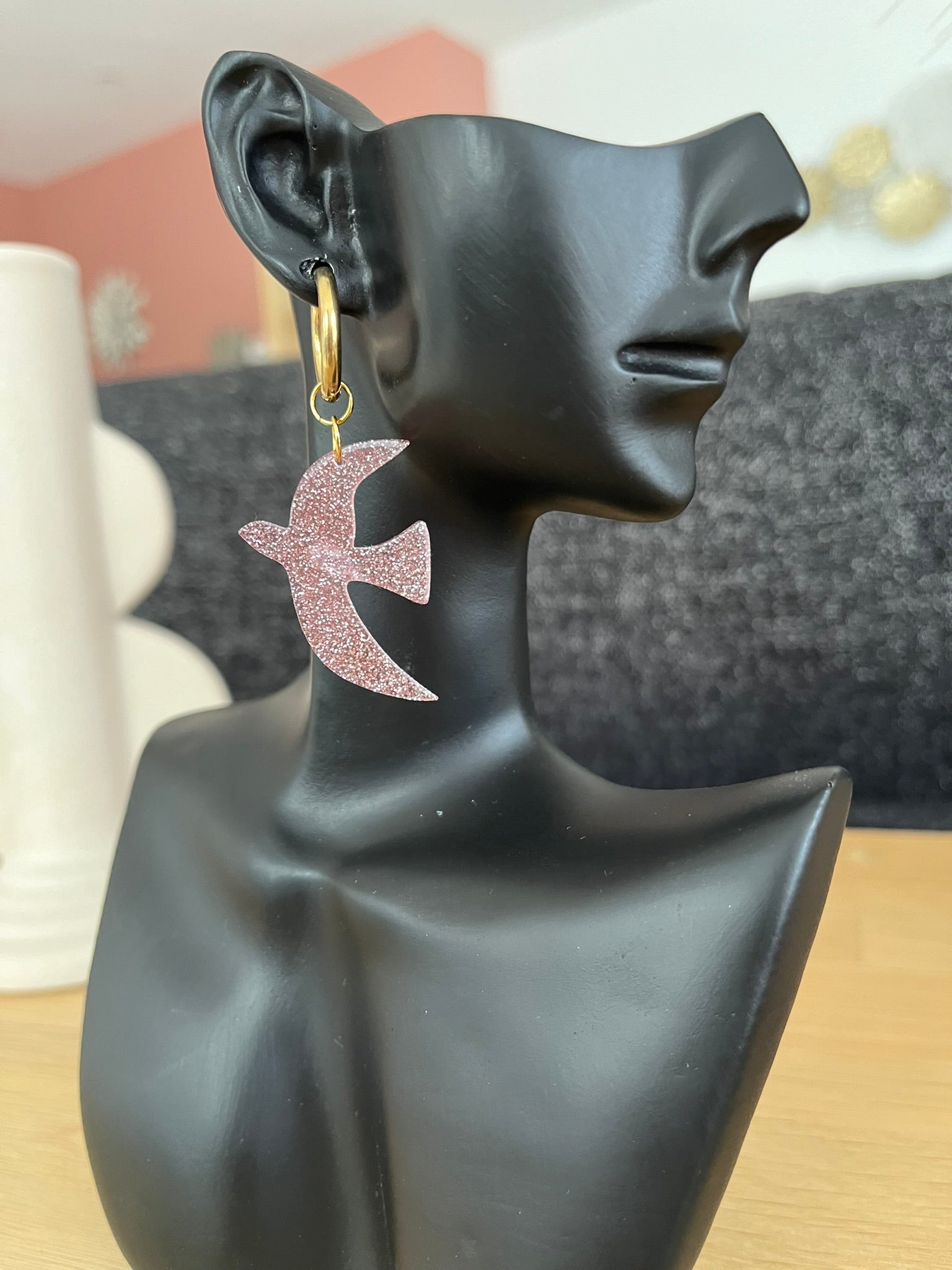 Boucles d'oreilles fantaisie fait main.
Créoles en acier inoxydable doré. Pendentifs hirondelle en acrylique rose pailleté.