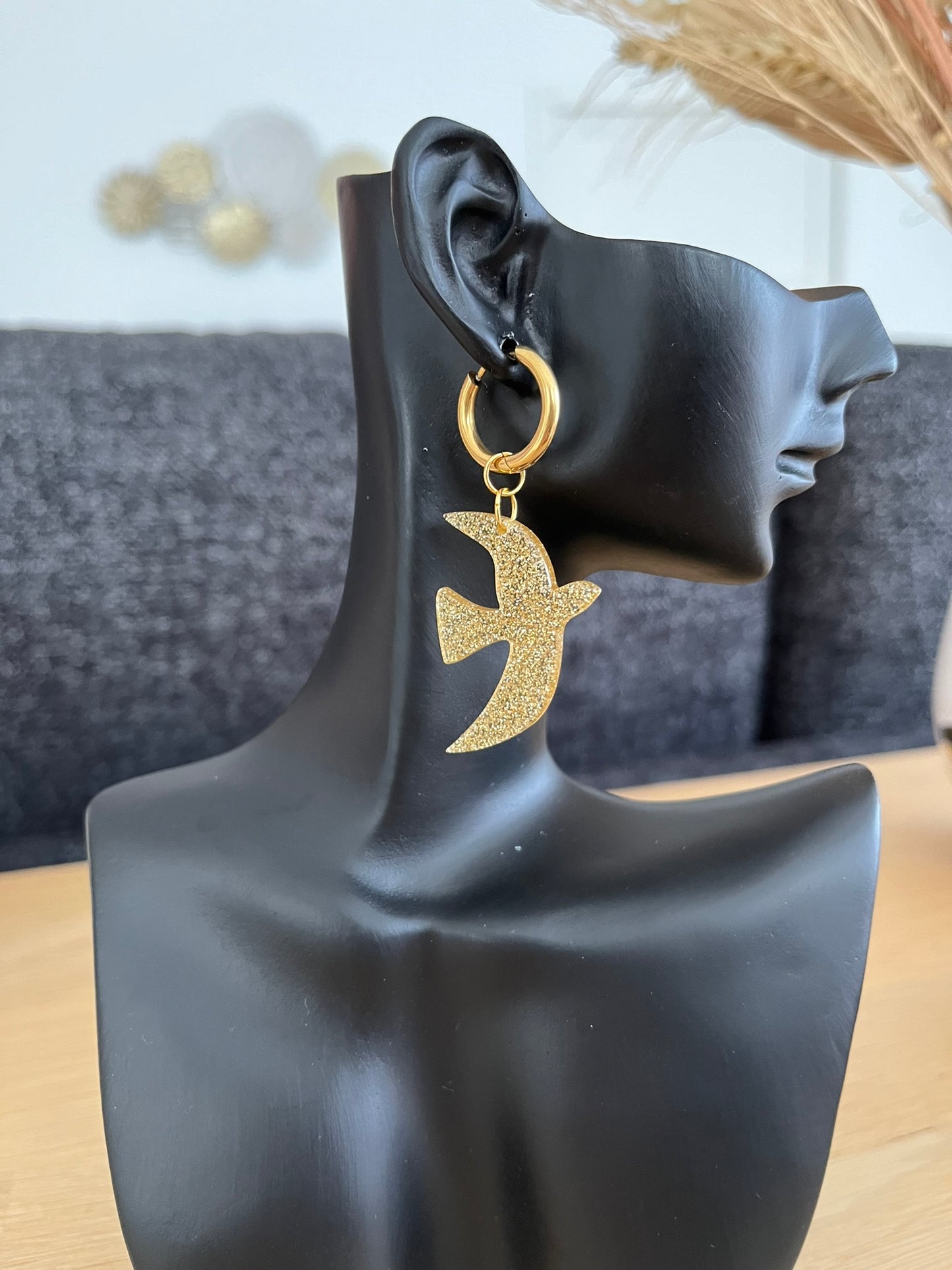 Boucles d'oreilles fantaisie fait main.
Créoles en acier inoxydable doré. Pendentifs hirondelle en acrylique doré pailleté.