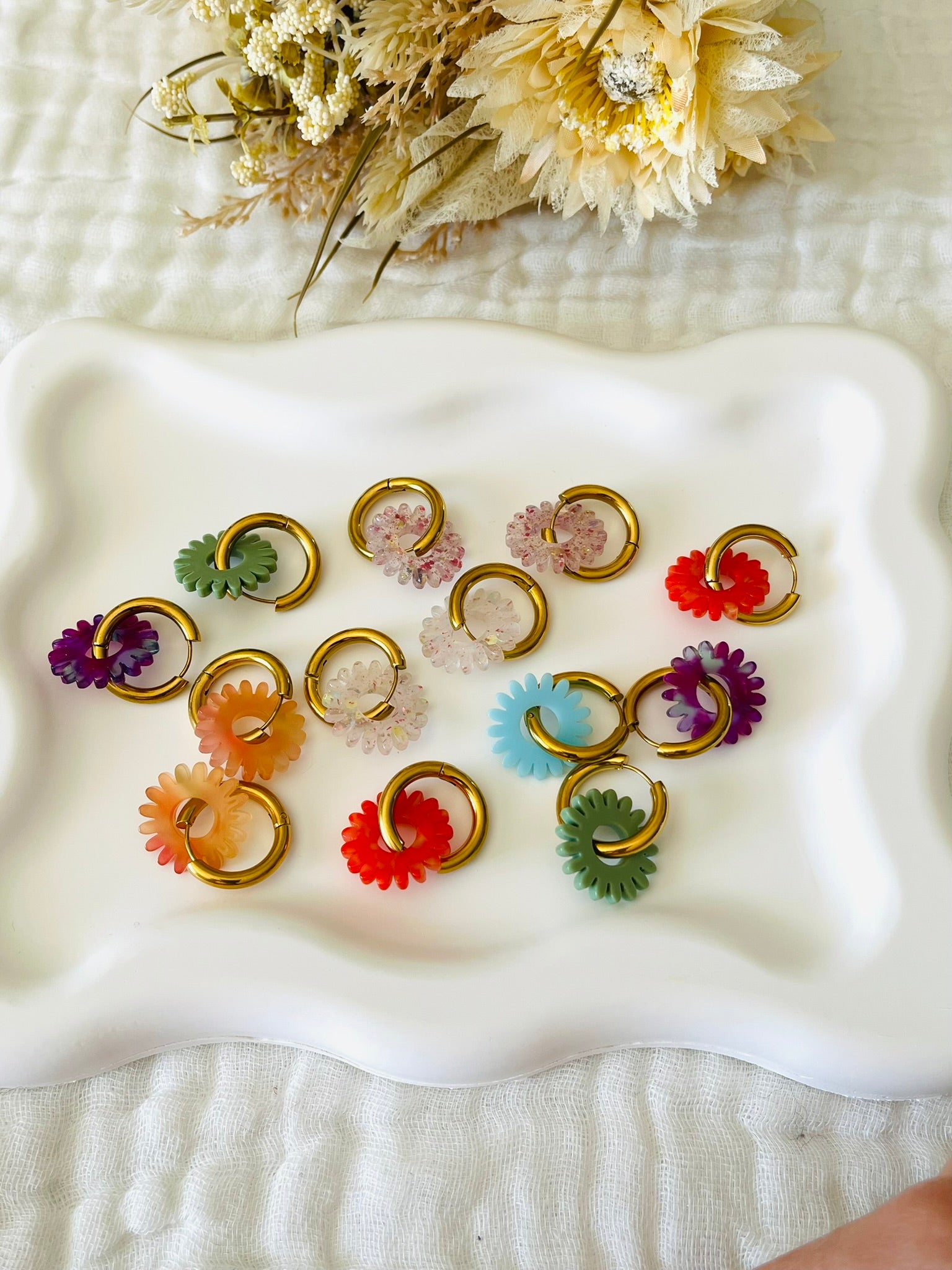 Boucles d'oreilles fantaisie.
Créoles en acier inoxyable doré.
Pampilles fleur, marguerite en acrylique.
Bijou fantaisie fait main.