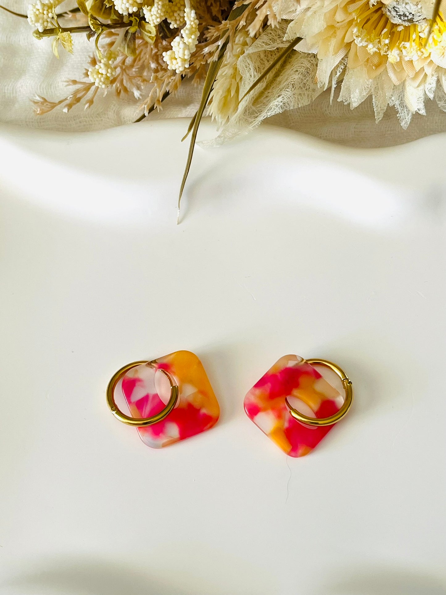 Boucles d'oreilles fantaisie fait main.
Créoles en acier inoxydable avec pampilles interchangeables.
Pampilles carrées couleur marbré rose et orange et transparent.
Bijou fantaisie fait main.