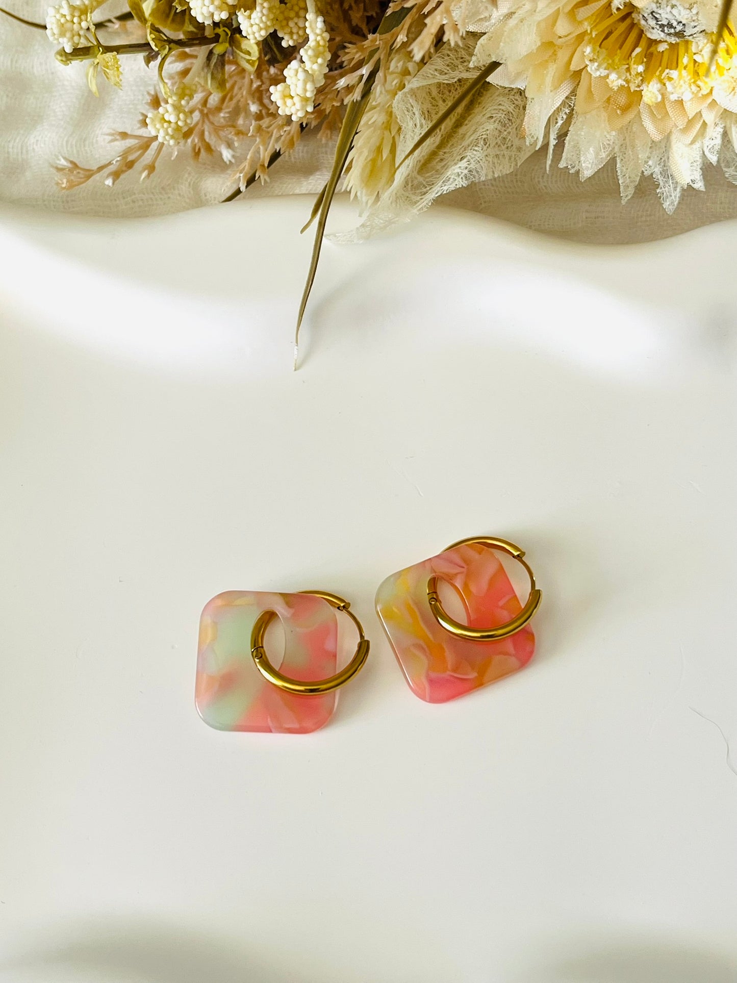 Boucles d'oreilles fantaisie fait main.
Créoles en acier inoxydable avec pampilles interchangeables.
Pampilles carrées couleur marbré rose vert, orange et transparent.
Bijou fantaisie fait main.